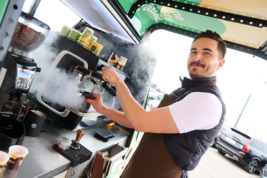 Ein Barista von café+co im café+co Mobil, der einen Kaffee zubereitet